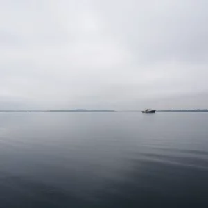 A calm waterway with a fishing boat, symbolizing loss and hope.