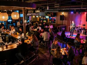 A lively scene with people enjoying food and drinks at a cocktail bar in Huntsville
