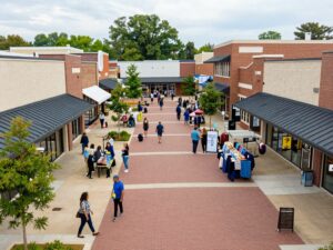 Community retail center in Huntsville, Alabama filled with shoppers and various storefronts.