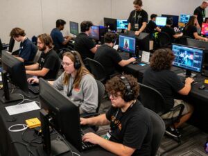 A vibrant scene at ChargerCon with attendees engaging in various gaming activities.